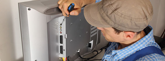 Elektriker repariert in Franfurt ein elektronisches Gerät, hier einen Fernseher