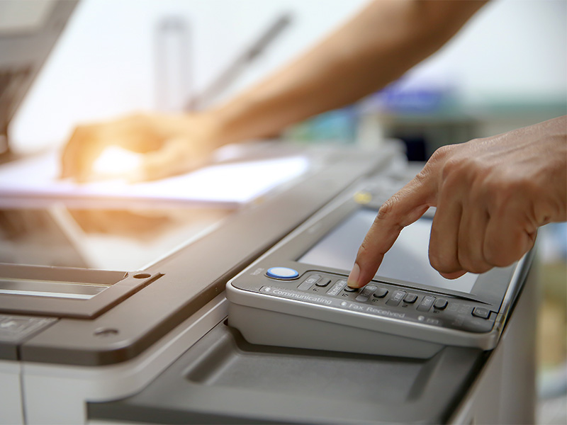 Nahaufnahme eines Geschäftsmanns, der im Büro Kopiergerät bedient und Scan- bzw. Kopiervorgang für Dokumente startet auslöst